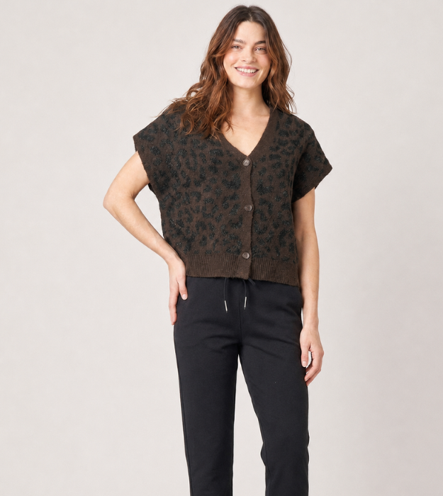 Femme portant un gilet léopard sans manches marron à motif léopard boutonnée sur le devant, associé à un pantalon noir.