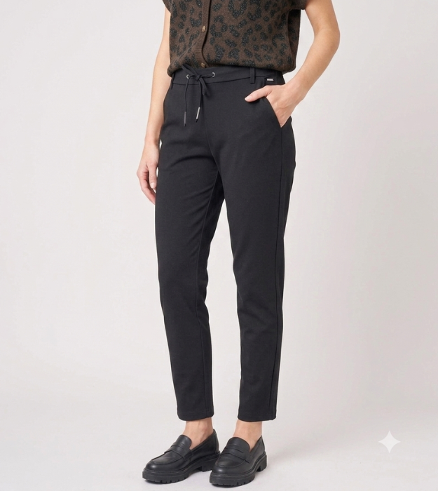 Photo de face d'une femme portant un pantalon noir femme casual chic ajusté, une ceinture avec cordon de serrage et des mocassins.