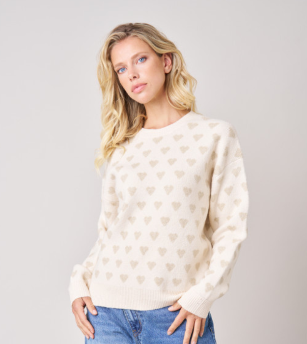 Pull femme écru en maille douce à imprimé cœurs beiges, manches longues et col rond.