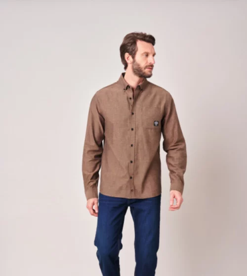 Homme portant une chemise marron à manches longues et un pantalon bleu