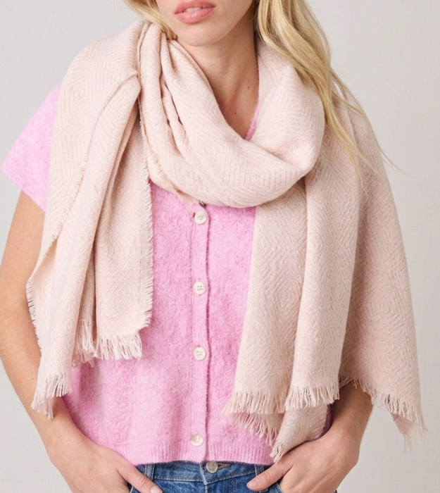 Écharpe beige à franges pour femme portée autour du cou avec un gilet rose