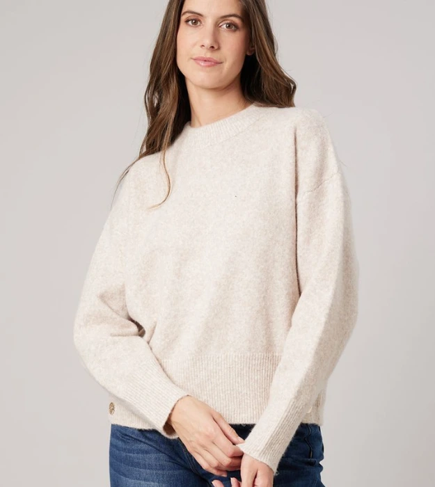 Femme portant un pull beige en maille douce à col rond