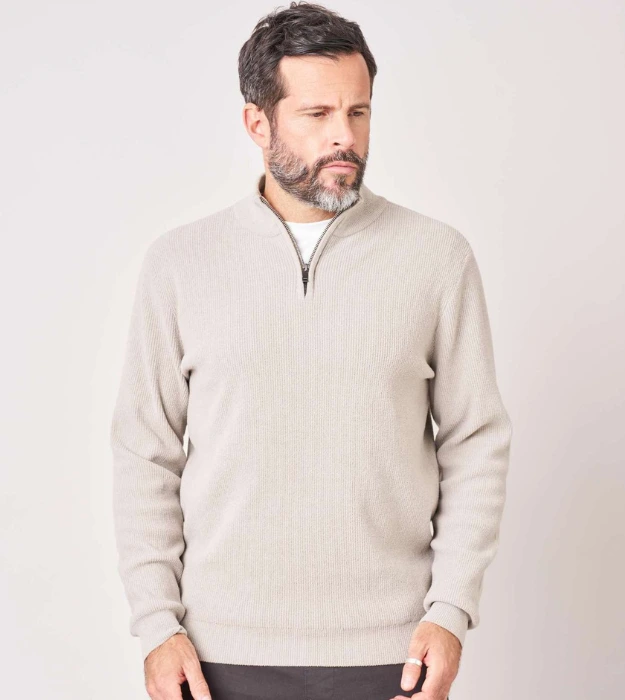 Homme portant un pull beige à manches longues avec col montant zippé