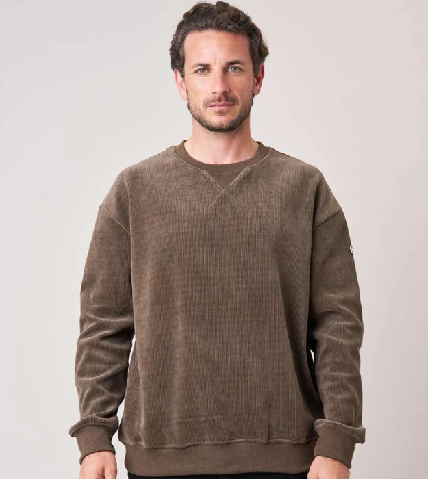 Homme portant un sweat marron à col rond et texture côtelée